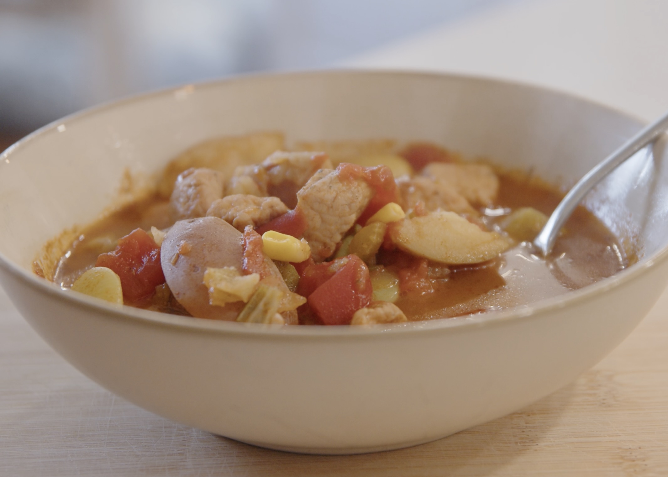 Pork burgoo in a bowl with spoon